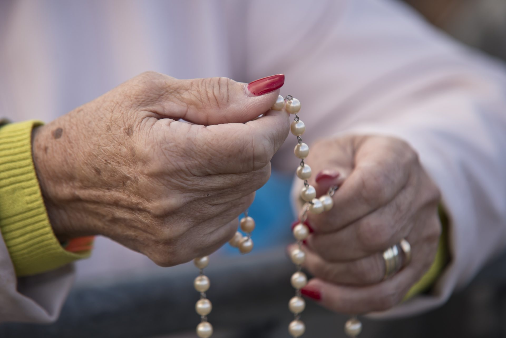 Hands holding a rosary in prayer