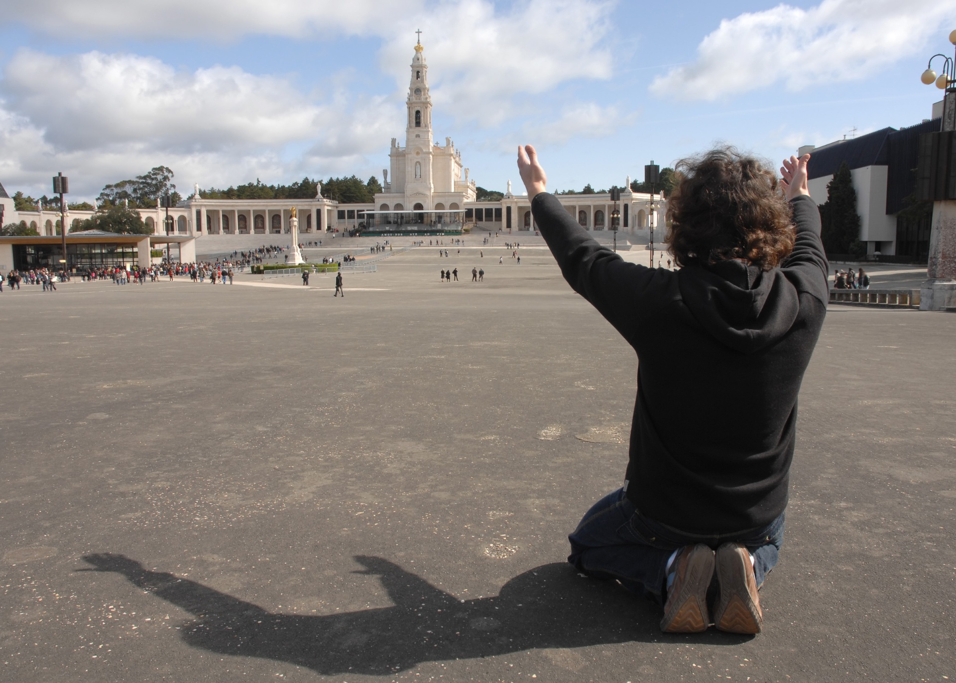 Pilgrim kneeling in prayer at Fátima square